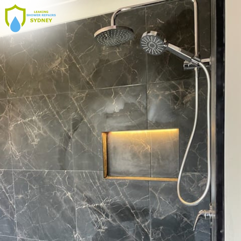 A modern shower featuring a sleek marble wall and a stylish shower head, highlighting expert leaking shower repair services.