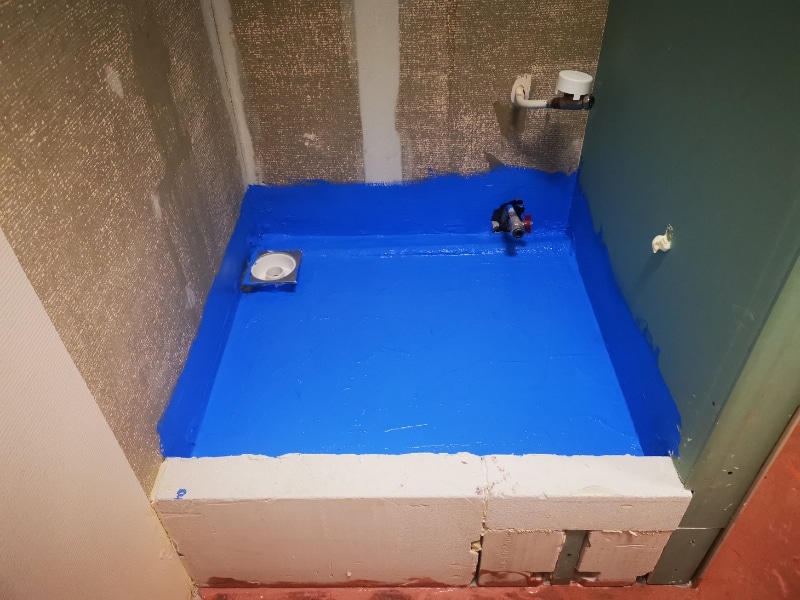 A drain with a waterproof membrane is applied, demonstrating a key step in waterproofing a bathroom.