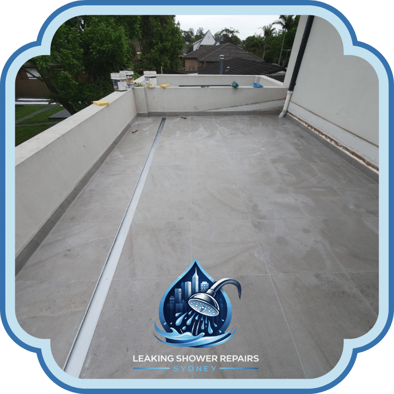 Tiled rooftop area with drainage channel and waterproofed surface, showing completed Leaking Rooftop Repairs Services on a residential building.