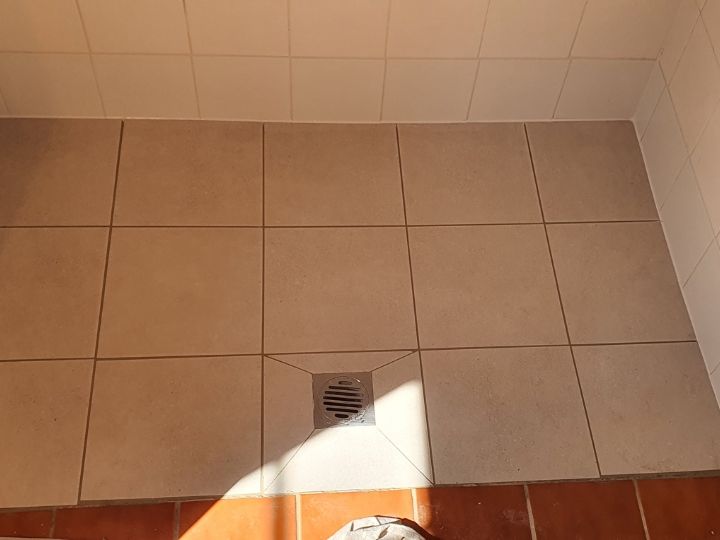 Technician resealing a shower in Cumberland without removing tiles
