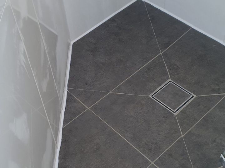 Technician resealing a shower in The Hills Shire without removing tiles